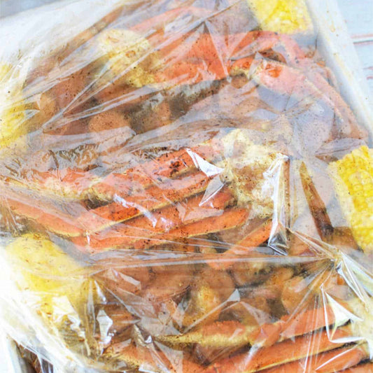 LA seafood boil catering: snow crab legs in garlic-butter bags, ready for delivery.