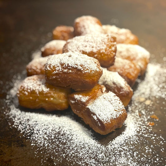Classic New Orleans Beignets delivered fresh overnight directly from Louisiana! ONly at Boil Baby Boil - One dozen Beignets covered in powdered sugar with available filling chocolate, caramel, or strawberry.