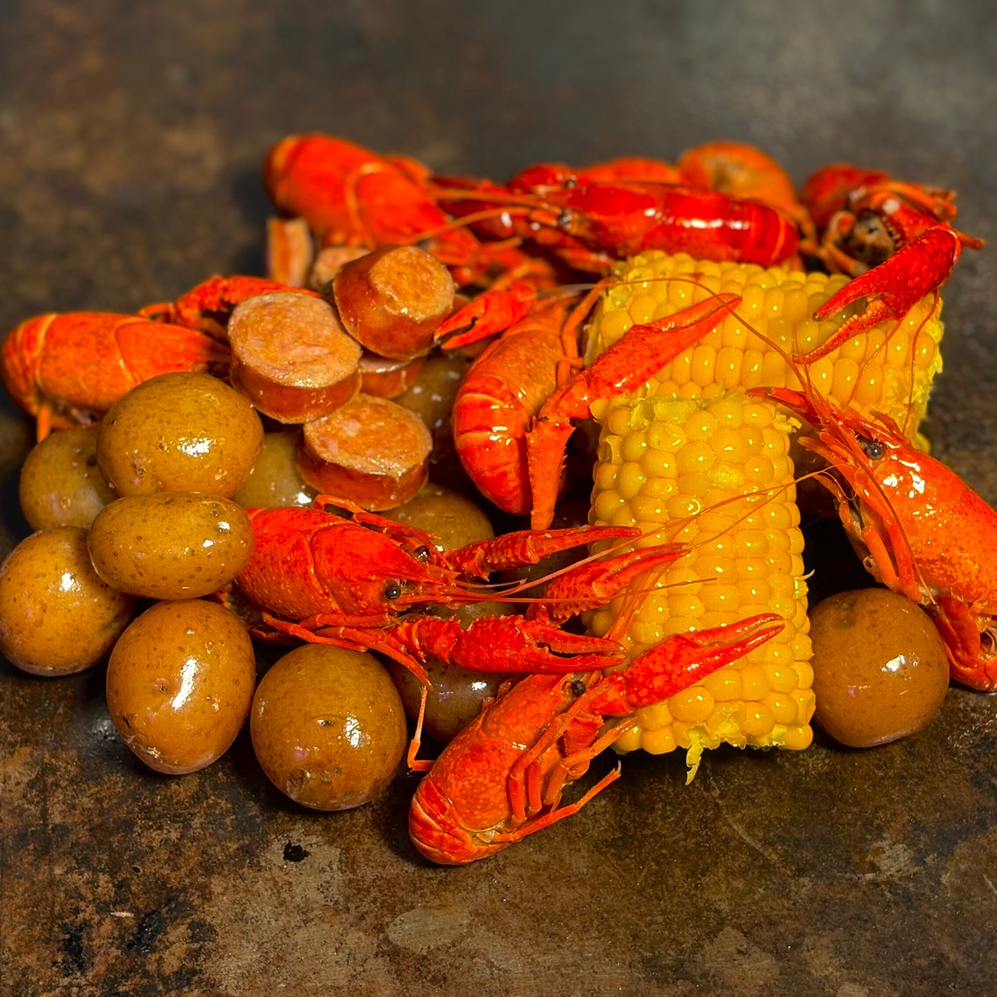 Best seafood boil bags for home cooking a pile of crawfish, andouille sausage, potatoes, and corn on the cob