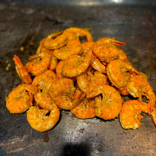 Succulent Cajun shrimp tossed in garlic butter, served in a sizzling seafood boil with herbs and spices.