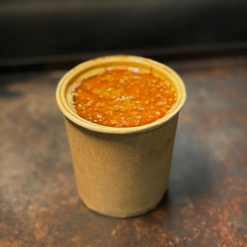 Kraft paper cup filled with rich golden Cajun butter sauce — one of Boil Baby Boil’s bold dipping sauce options included with every seafood boil bag