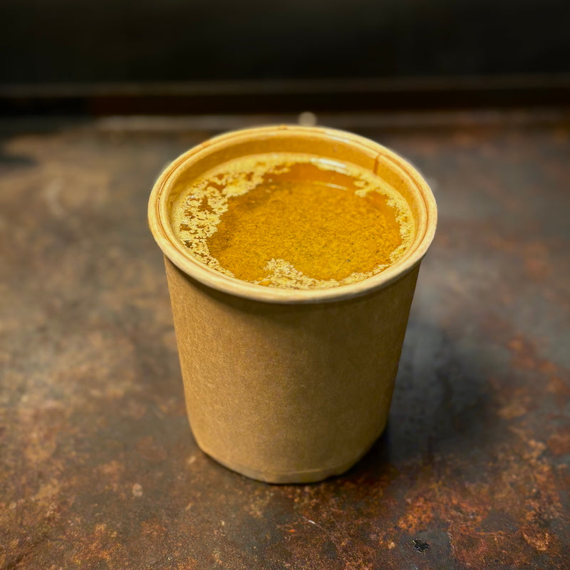 Lemon pepper butter sauce in a kraft paper cup — one of Boil Baby Boil’s zesty and bright sauce options for seafood boil bags