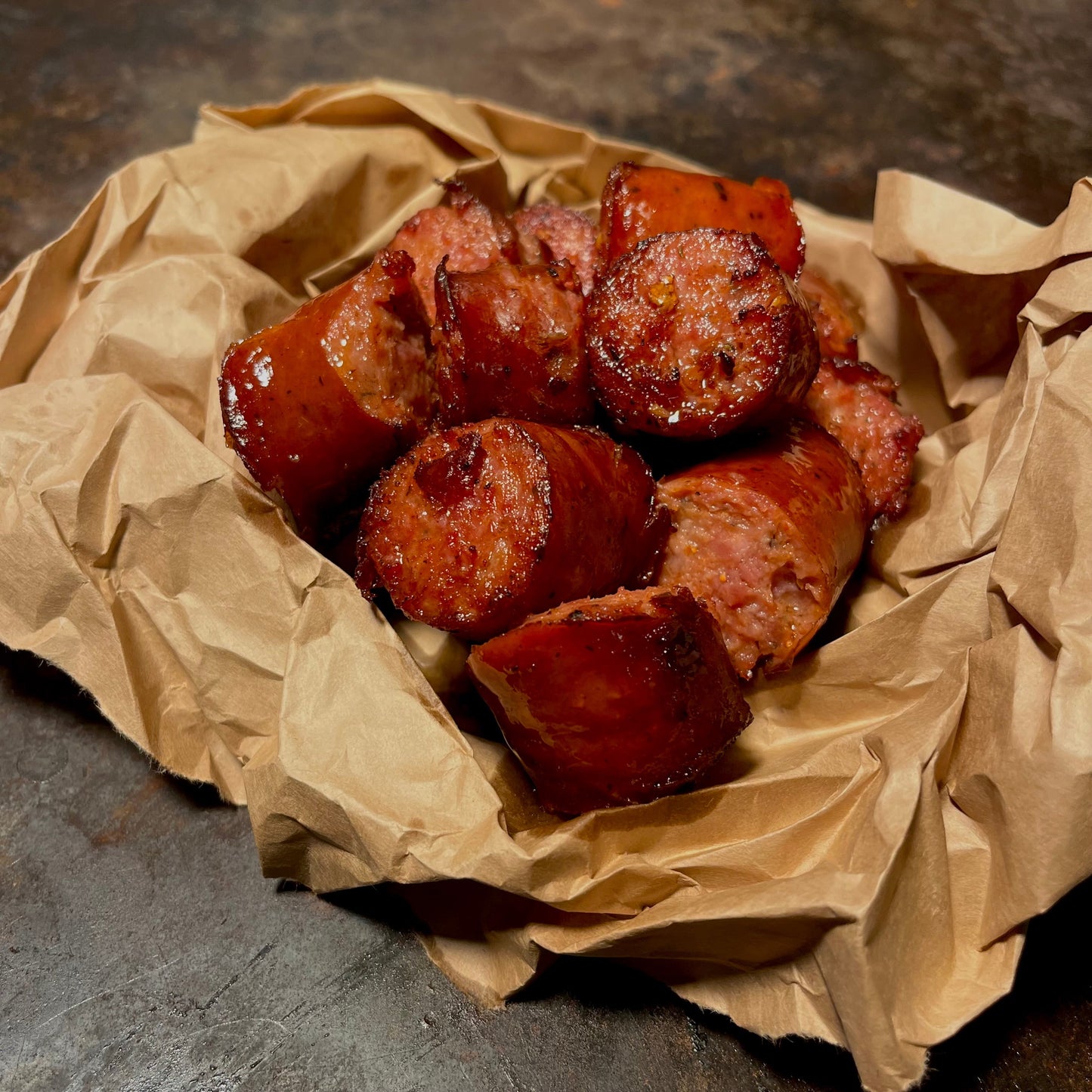 Sliced smoked andouille sausage served rustic-style—perfect spicy sidekick to any Cajun seafood boil in West Hollywood. A bold, savory favorite for late-night food lovers and sausage fans alike.