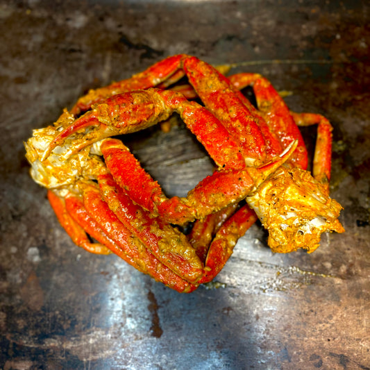 Steaming hot crab legs seasoned with Cajun spices, served with lemon wedges and melted butter for dipping.