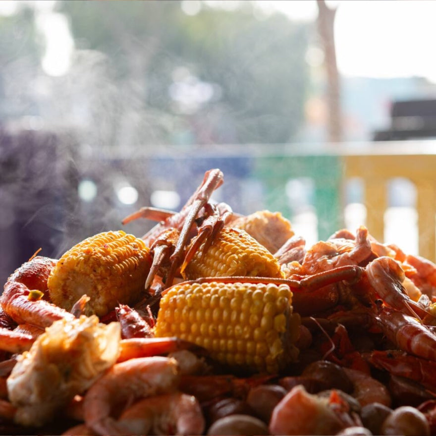 Boiled crawfish and corn on the table at a Cajun seafood boil in Los Angeles