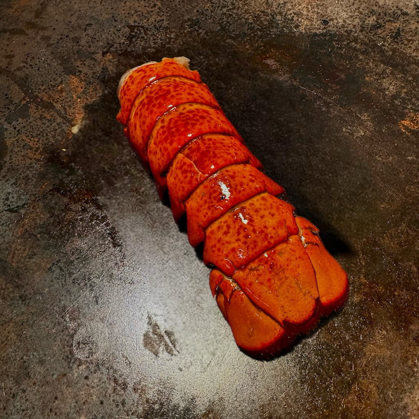 Lobster tail on a rustic metal surface