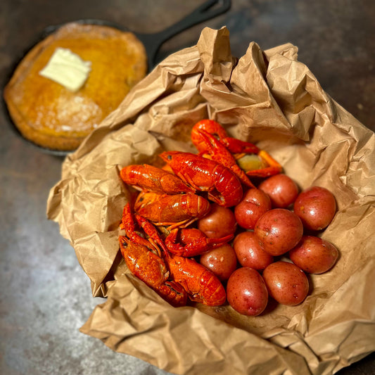 Cajun seafood boil with crawfish and potatoes served on newspaper table setup in Los Angeles