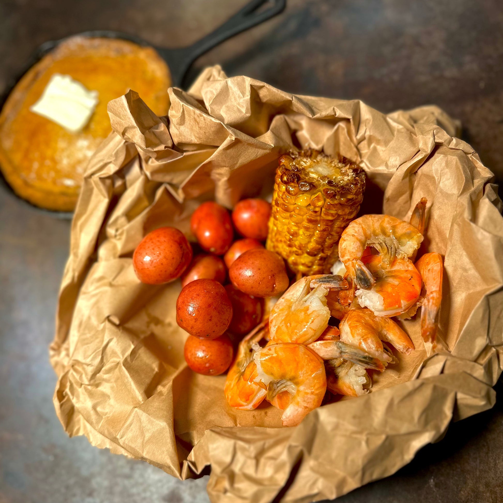 West Hollywood Cajun seafood combo with peel-and-eat shrimp, Cajun potatoes, sweet corn, and a side of golden honey-butter cornbread—perfect for late-night food delivery in LA.